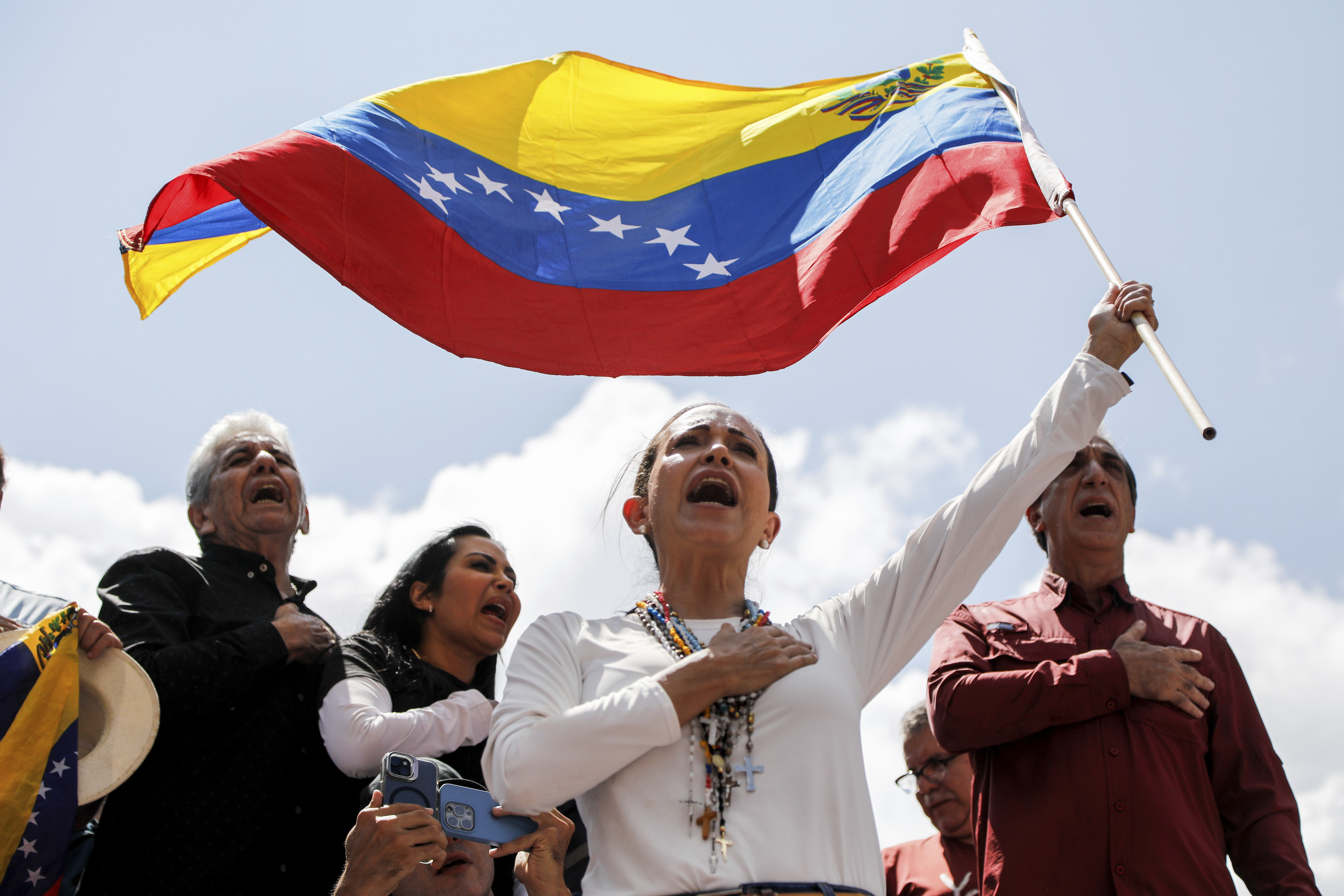 Opposition leader Maria Corina Machado waves a Venezuelan national flag during a rally to protest official results that declared President Nicolas Maduro the winner of the July presidential election.